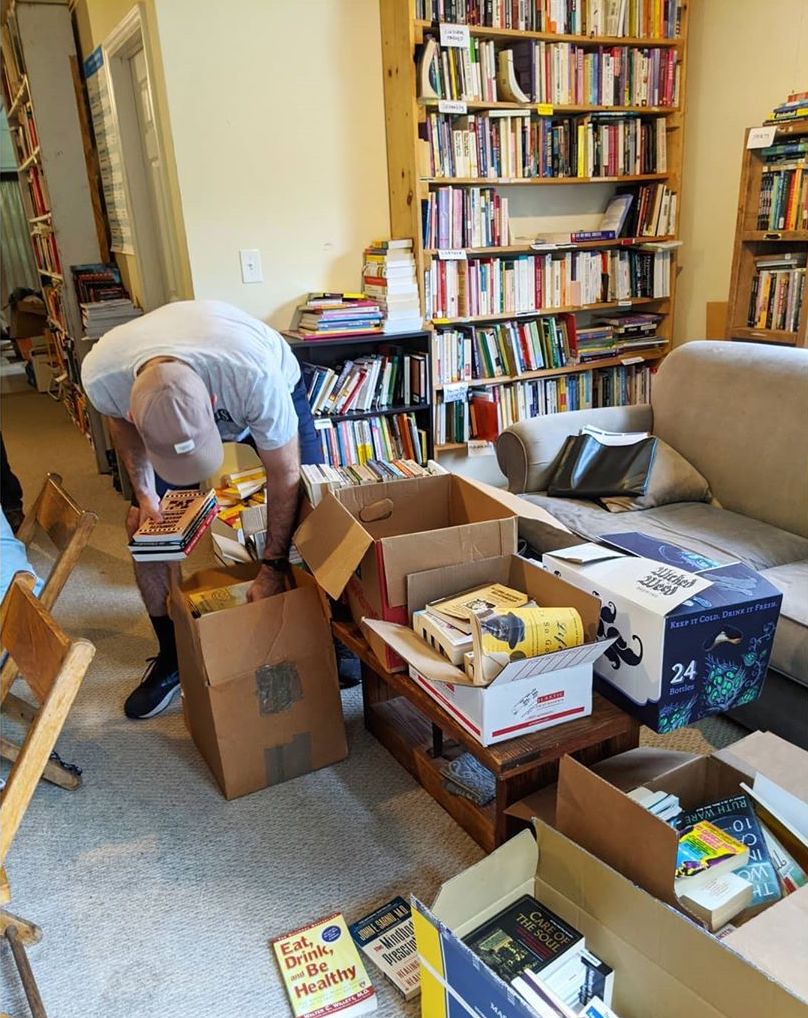 A volunteer sorting through books of boxes.